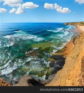 Summer Atlantic ocean coast landscape and Monte Clerigo beach (Aljezur, Algarve, Portugal). Blue sky with some cumulus clouds.Three shots stitch high-resolution image.