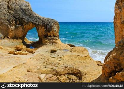 Summer Atlantic rocky coast view with natural arch (Albufeira outskirts, Algarve, Portugal).