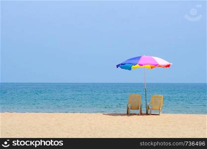 Summer background, chair and colorful umbrella on beach and sea background with copy space