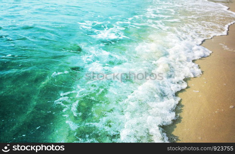 Summer background of turquoise color sea with wave on the sand beach