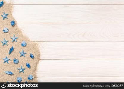 Summer background with white wooden table with many seashell and sand. Top view copy space for text