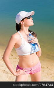 Summer beach active woman enjoy sunset sitting in fitness outfit