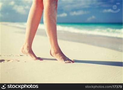 summer, beach, leisure and body part concept - closeup of woman legs on sea shore
