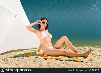 Summer beach stunning woman posing in bikini parasol background