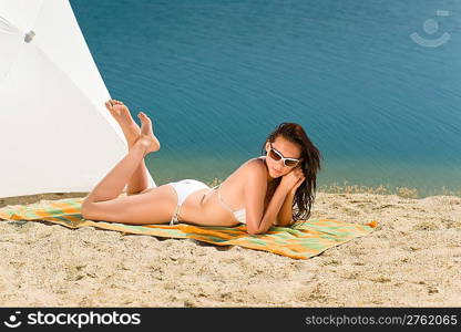 Summer beach stunning woman sunbathing in bikini parasol background