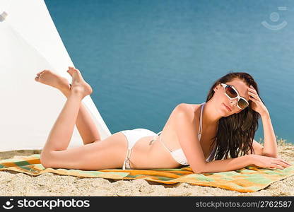 Summer beach stunning woman sunbathing in bikini parasol background