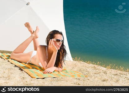 Summer beach stunning woman sunbathing in bikini parasol background