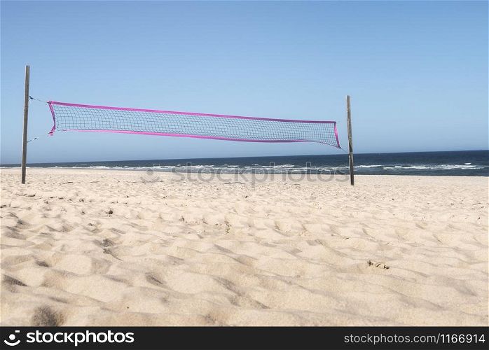 Summer beach with volleyball net, fine sand, blue water of the North Sea and clear sky, on Sylt island, Germany. Sunny beach day. Summer vacay fun.
