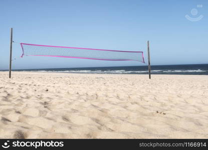 Summer beach with volleyball net, fine sand, blue water of the North Sea and clear sky, on Sylt island, Germany. Sunny beach day. Summer vacay fun.