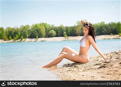 Summer beach young woman sitting on seaside alone