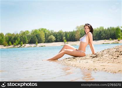 Summer beach young woman sitting on seaside alone