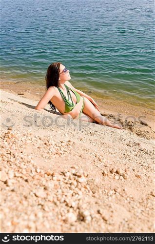 Summer beach young woman sunbathing in bikini alone