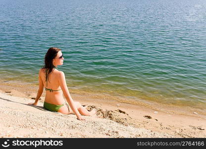 Summer beach young woman sunbathing in bikini alone