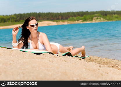 Summer beach young woman sunbathing in bikini alone