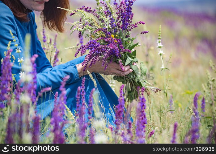 summer - beautiful girl on a meadow with a bouquet of wildflowers