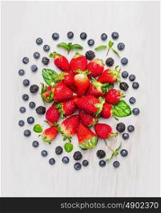 Summer berries: blackberries, blueberries, strawberries , composing on white wooden background, top view