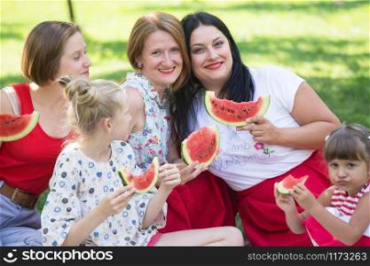 Summer - big happy family at a picnic with watermelon. Fun juicy summer and bright family picnic