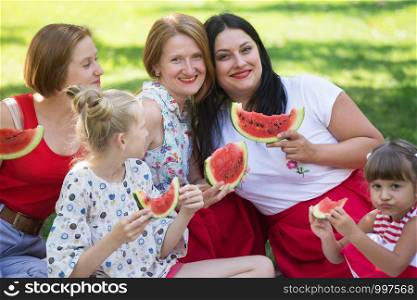 Summer - big happy family at a picnic with watermelon. Fun juicy summer and bright family picnic
