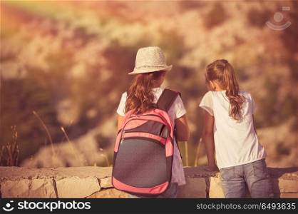 Summer camp adventures, two little girls best friends enjoying mountains hike, schoolchildren on outdoor tour, happy summer holidays in the camp. Kids enjoying hike