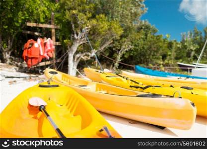 summer, canoes, activities and vacations concept - canoes on sandy beach
