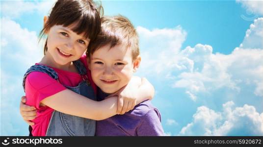 summer, childhood, family, friendship and people concept - two happy kids hugging over blue sky with clouds background