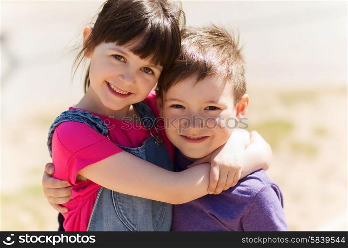 summer, childhood, family, friendship and people concept - two happy kids hugging outdoors