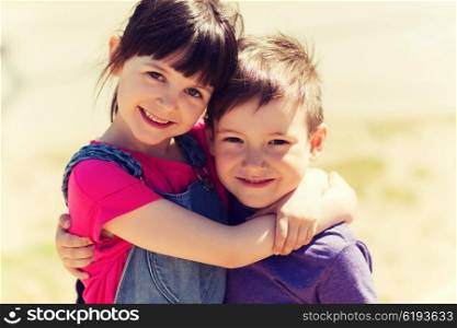summer, childhood, family, friendship and people concept - two happy kids hugging outdoors