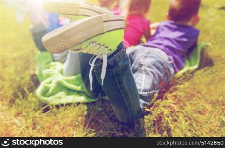summer, childhood, leisure and people concept - close up of happy kids lying on picnic blanket outdoors. close up of kids lying on picnic blanket outdoors