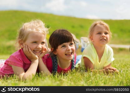 summer, childhood, leisure and people concept - group of happy kids lying on blanket or cover outdoors