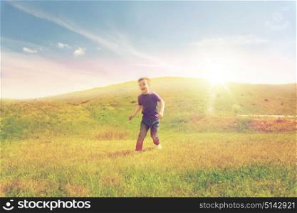 summer, childhood, leisure and people concept - happy little boy running on green field outdoors. happy little boy running on green field outdoors