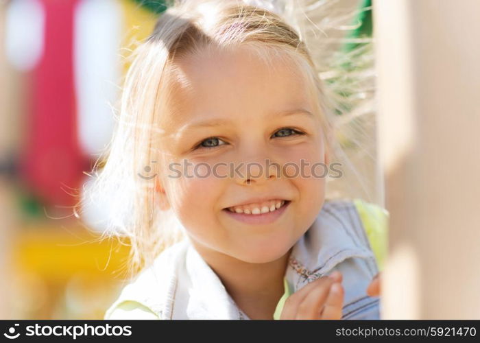 summer, childhood, leisure and people concept - happy little girl on children playground climbing frame