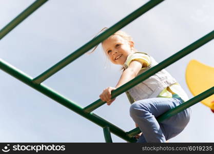 summer, childhood, leisure and people concept - happy little girl on children playground climbing frame