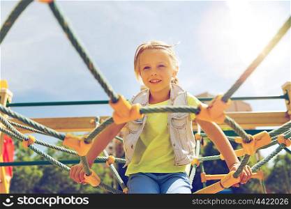 summer, childhood, leisure and people concept - happy little girl on playground climbing frame