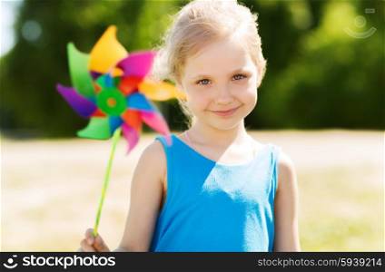 summer, childhood, leisure and people concept - happy little girl with colorful pinwheel toy outdoors