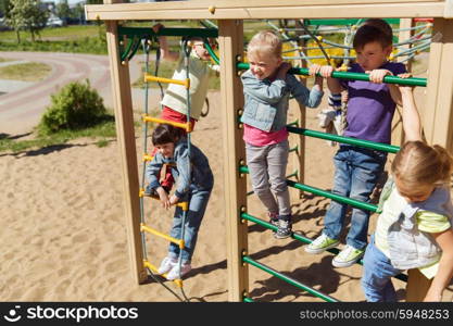 summer, childhood, leisure, friendship and people concept - group of happy kids on children playground climbing frame