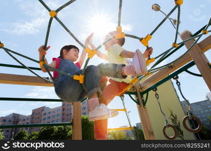 summer, childhood, leisure, friendship and people concept - group of happy kids on children playground climbing frame