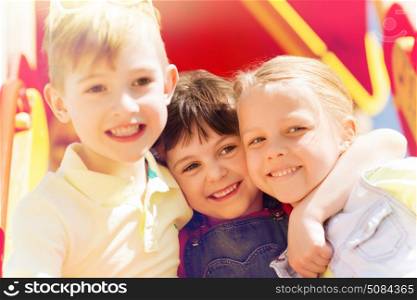 summer, childhood, leisure, friendship and people concept - group of happy kids hugging on children playground. group of happy kids on children playground. group of happy kids on children playground