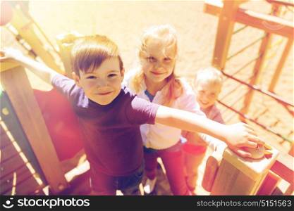 summer, childhood, leisure, friendship and people concept - group of happy kids on children playground. group of happy kids on children playground