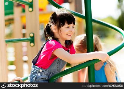 summer, childhood, leisure, friendship and people concept - group of happy little girls on children playground climbing frame