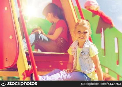 summer, childhood, leisure, friendship and people concept - happy kids on children playground climbing frame. happy kids on children playground