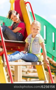 summer, childhood, leisure, friendship and people concept - happy kids on children playground climbing frame