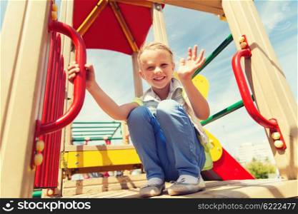 summer, childhood, leisure, gesture and people concept - happy little girl waving hand on children playground climbing frame