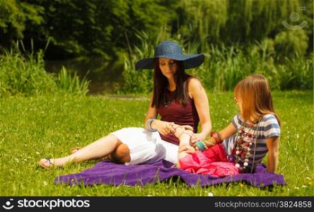 Summer children and happy family concept. Mother and daughter little girl having picnic playing in park outdoors.