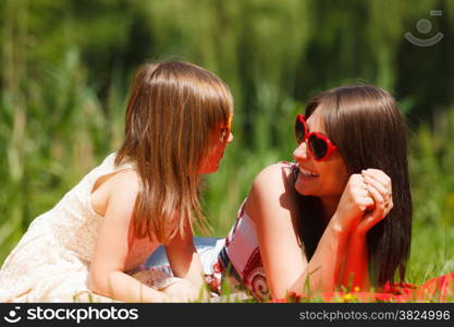 Summer children and happy family concept. Mother and daughter little girl in heart shaped sunglasses, having picnic playing in park outdoors.