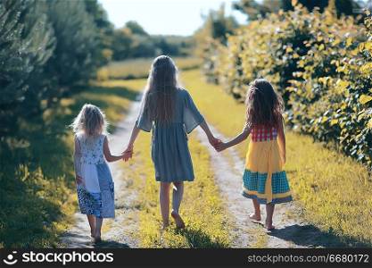 summer children&rsquo;s holiday / cheerful children&rsquo;s game, sisters happy and playing outdoors in summer