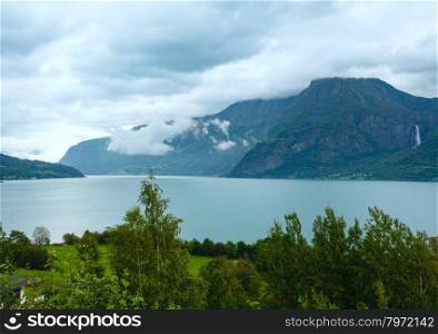 Summer cloudy mountain and fjord landscape (Norway).