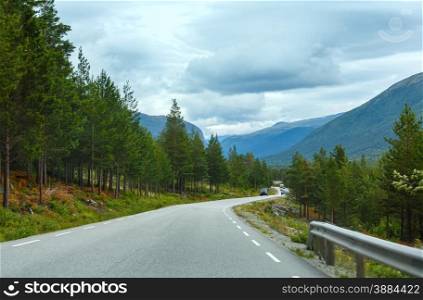 Summer cloudy mountain landscape with road (Norway).