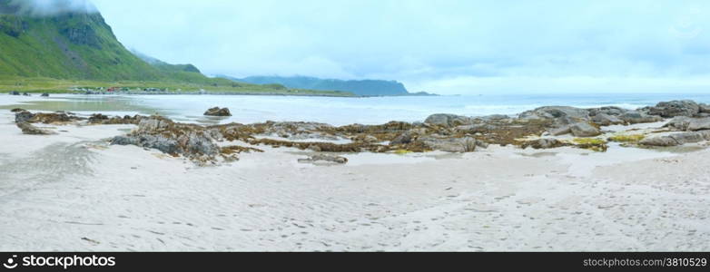 Summer cloudy view of the beach with white sand and alga on stones in Ramberg (Norway, Lofoten).