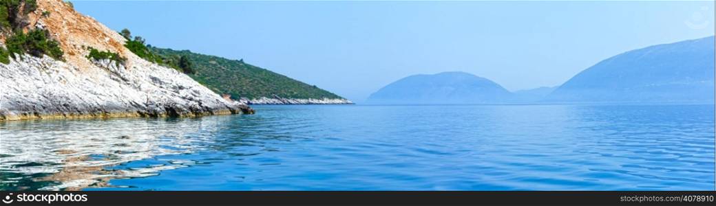 Summer coast view from motorboat (Kefalonia, not far from Agia Effimia, Greece) and Ithaka island on right. Panorama.