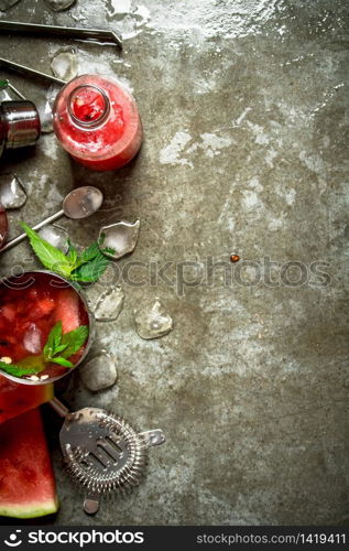 Summer cocktail. Watermelon slices with mint and ice in a shaker. On the stone table.. Watermelon chocktail with mint